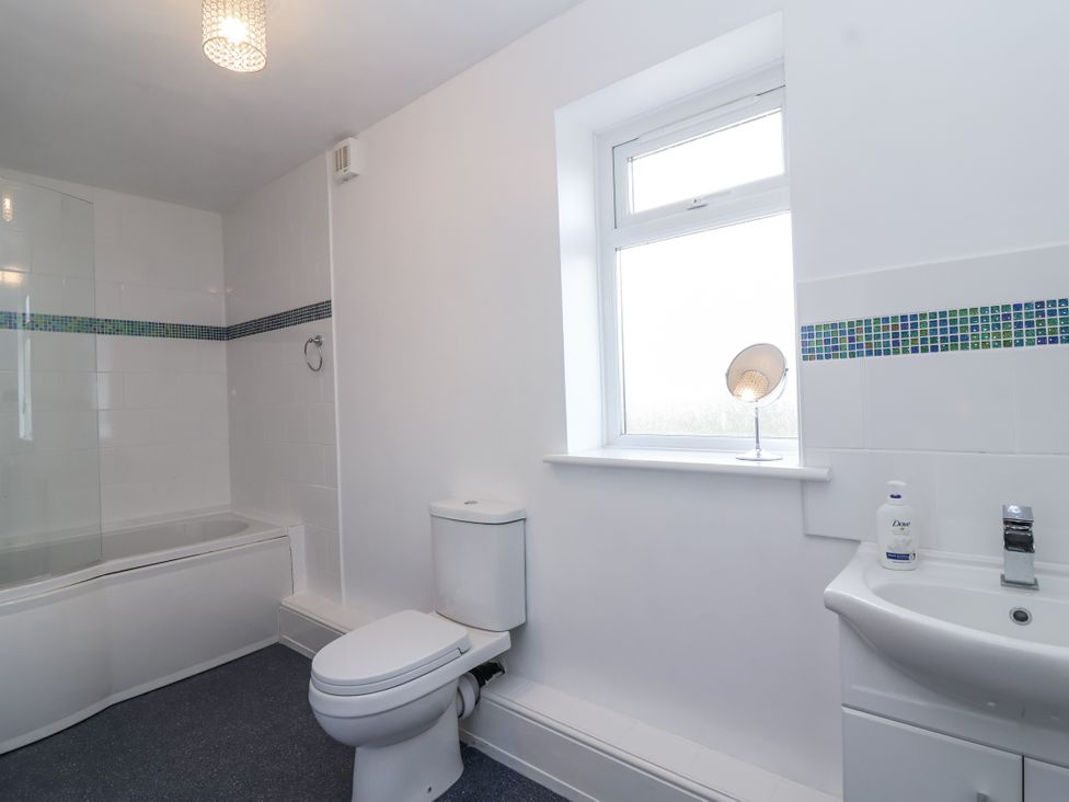 A bathroom with a bathtub, toilet, and sink at The Miners Cottage in Wells