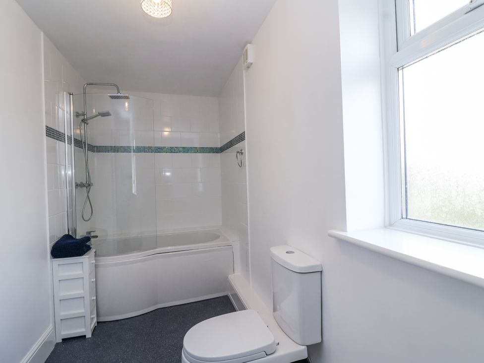 A bathroom with a shower and bathtub at The Miners Cottage in Wells