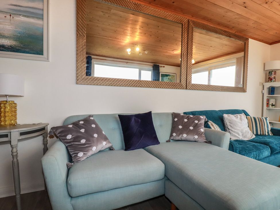 A living room with a couch and pillows at 38 Surf View in Newquay