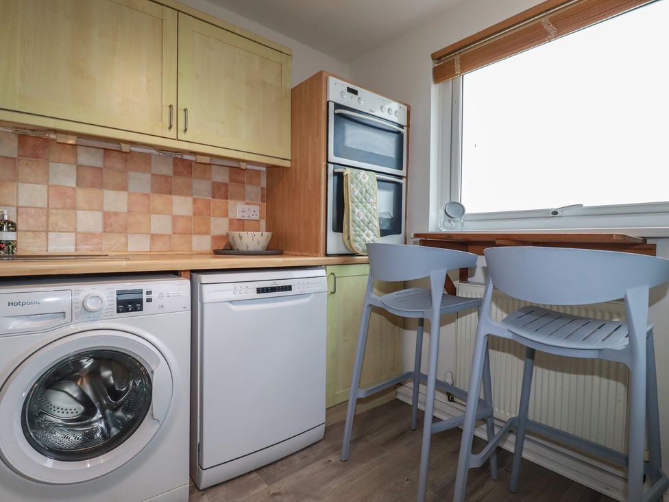 A kitchen with a washing machine and dishwasher at 38 Surf View Newquay