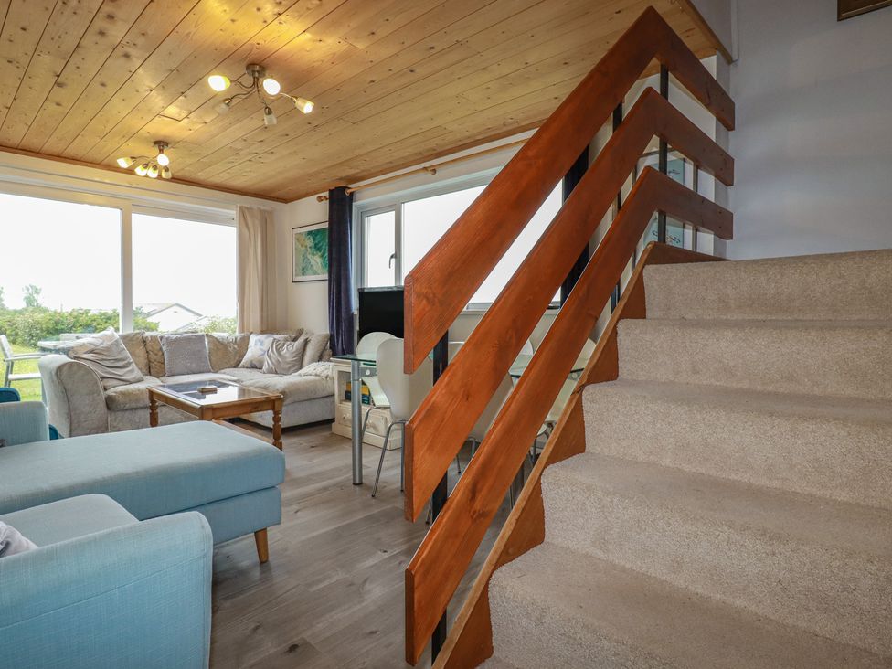 A living room with a staircase and a coffee table at 38 Surf View in Newquay