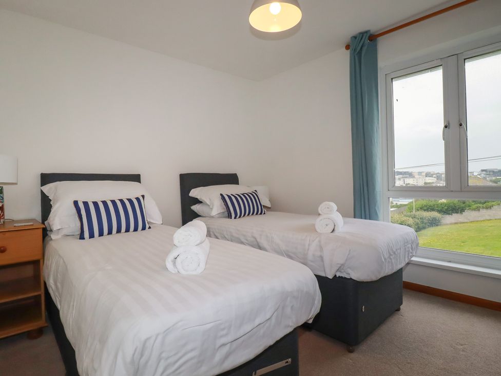 A bedroom with two single beds and a window at 38 Surf View in Newquay