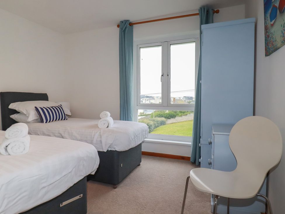 A bedroom with two beds and a window at 38 Surf View in Newquay