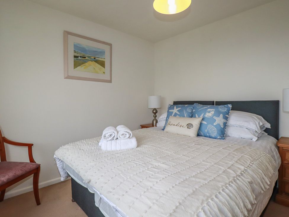 A bedroom with a bed and chair at 38 Surf View in Newquay