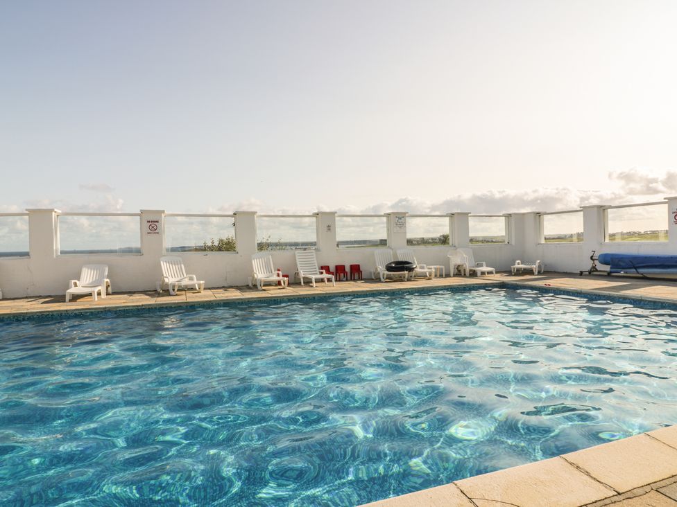 An outdoor swimming pool with chairs at Surf View in Newquay