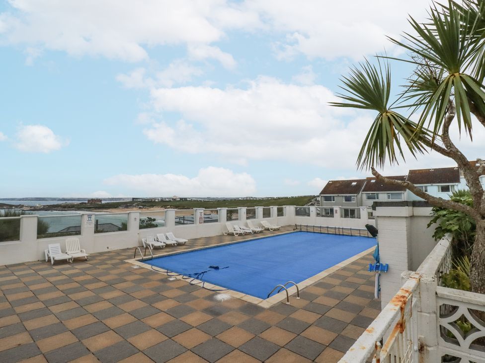 An outdoor swimming pool area with chairs at Surf View in Newquay