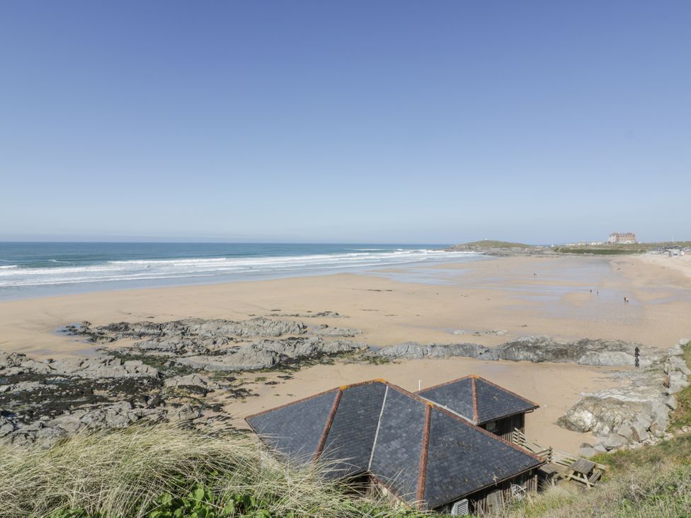 A beach with rocks and a hut at Surf View in Newquay