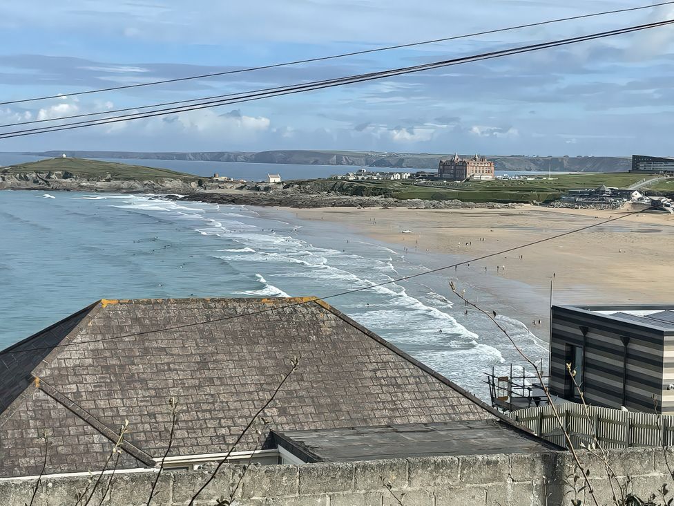 A beach view with waves and buildings at Surf View in Newquay