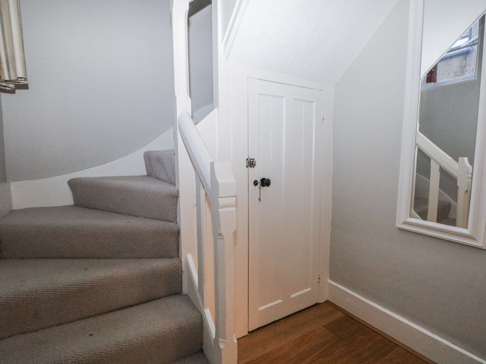 A staircase with a door and mirror at The Old School House in Windsor