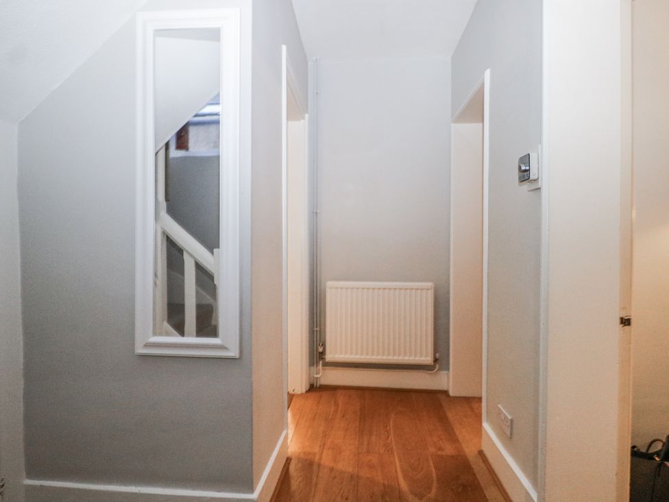A hallway with a staircase and a mirror at The Old School House in Windsor
