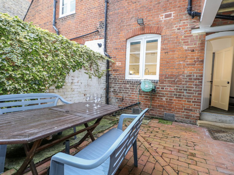 A garden with a wooden table and chairs at The Old School House in Windsor