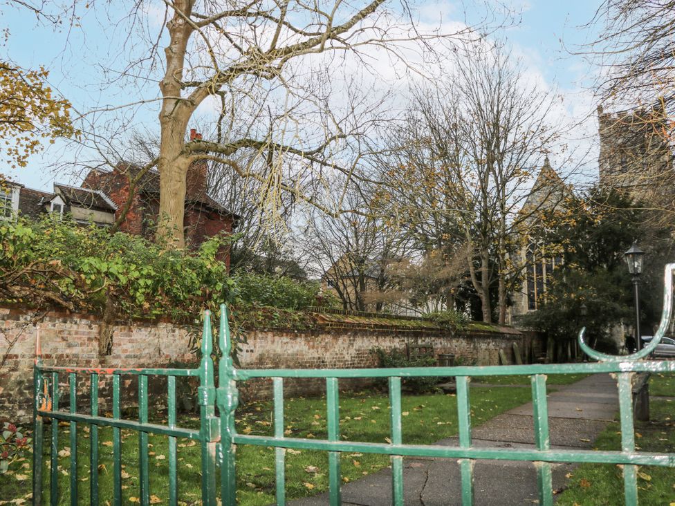 A pathway with trees and a brick wall at The Old School House in Windsor