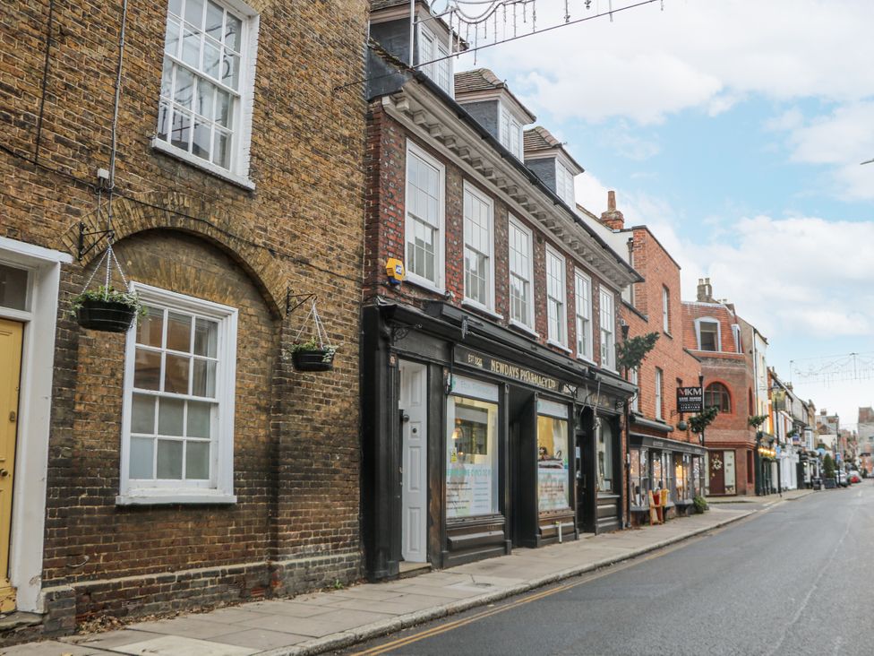 A street view with shops and hanging plants at The Old School House in Windsor