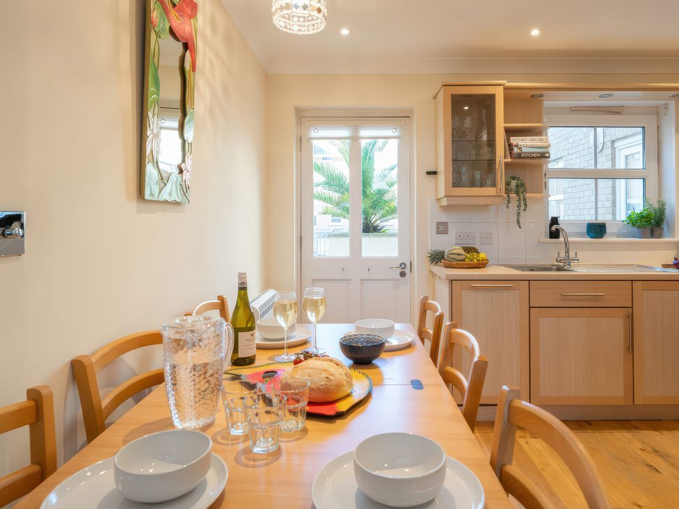 A kitchen with a table set for dinner at 17 Solent Landing in Bembridge
