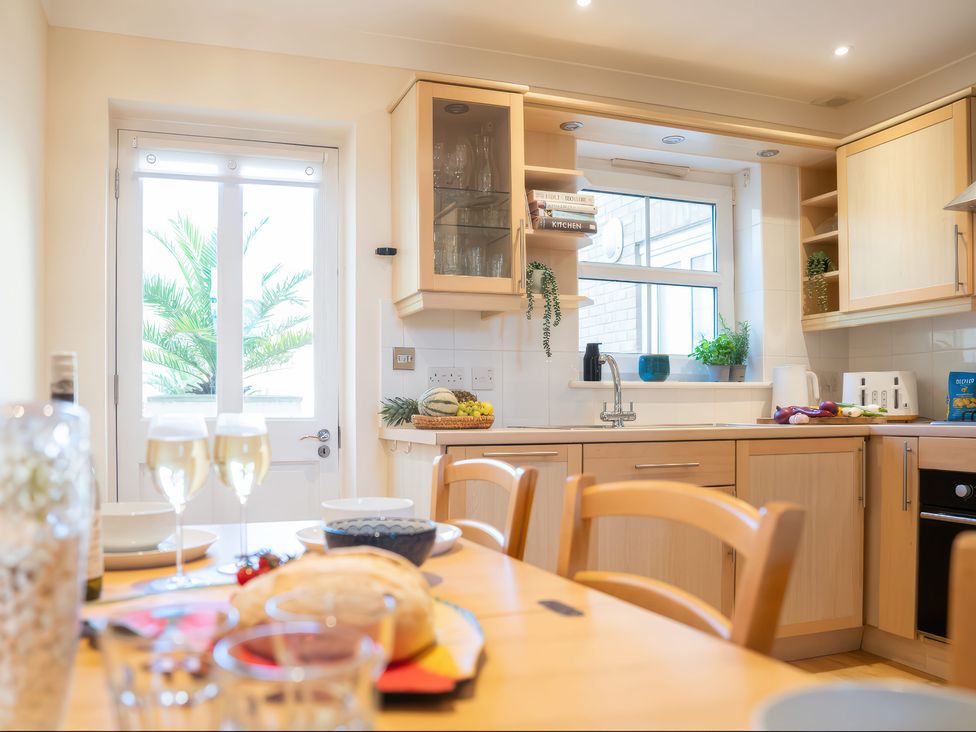 A kitchen with a dining table and sink at 17 Solent Landing in Bembridge