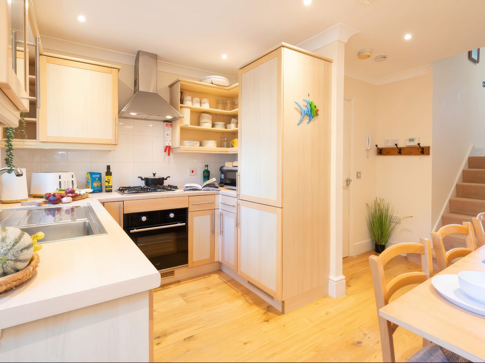 A kitchen with cabinets, stove, and sink at 17 Solent Landing in Bembridge
