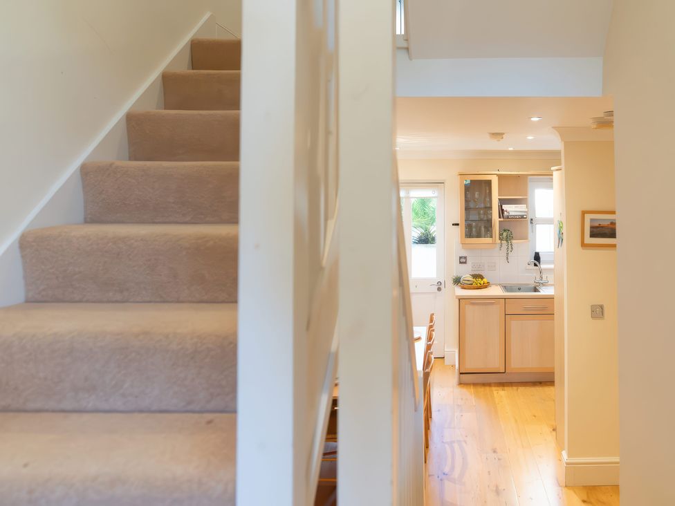 A hallway with a staircase and kitchen visible at 17 Solent Landing, Bembridge
