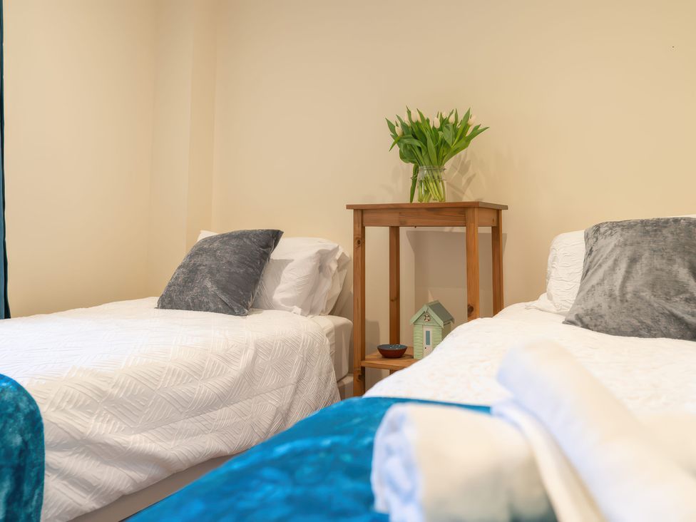A bedroom with two beds and a nightstand at 17 Solent Landing in Bembridge