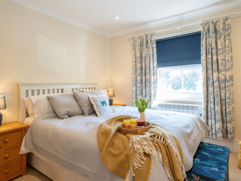 A bedroom with a bed and a tray of food at 17 Solent Landing in Bembridge
