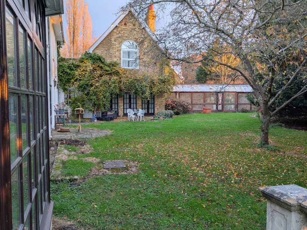 A garden with chairs and a table at Heath Lodge in Iver