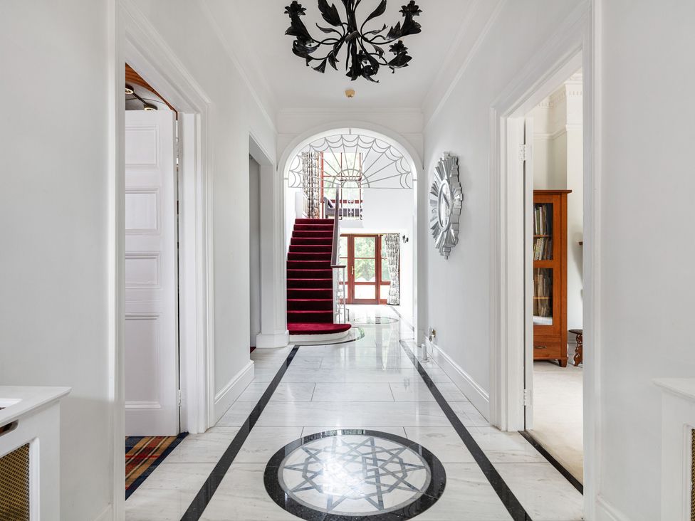 A hallway with a staircase and mirror at Violet House in Iver
