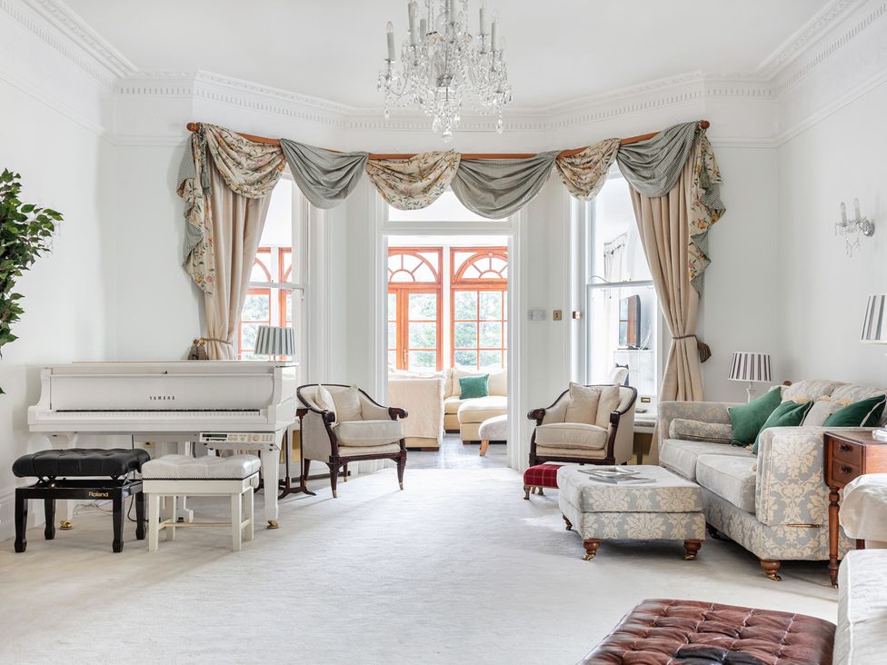 A living room with a piano and seating at Violet House in Iver