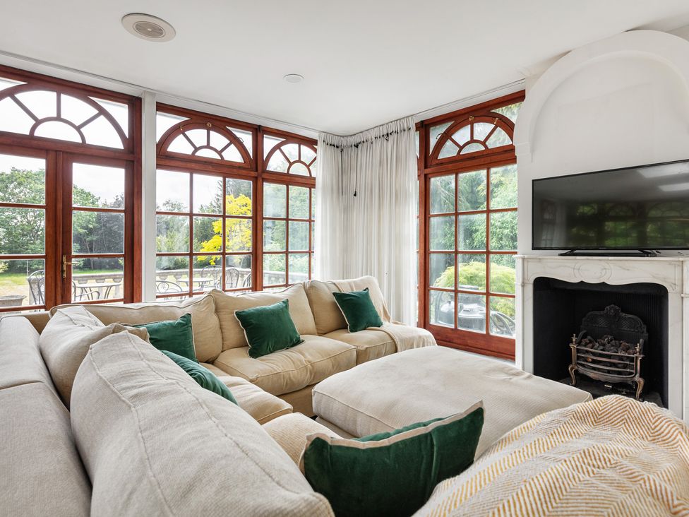 A living room with a sofa and television at Violet House in Iver