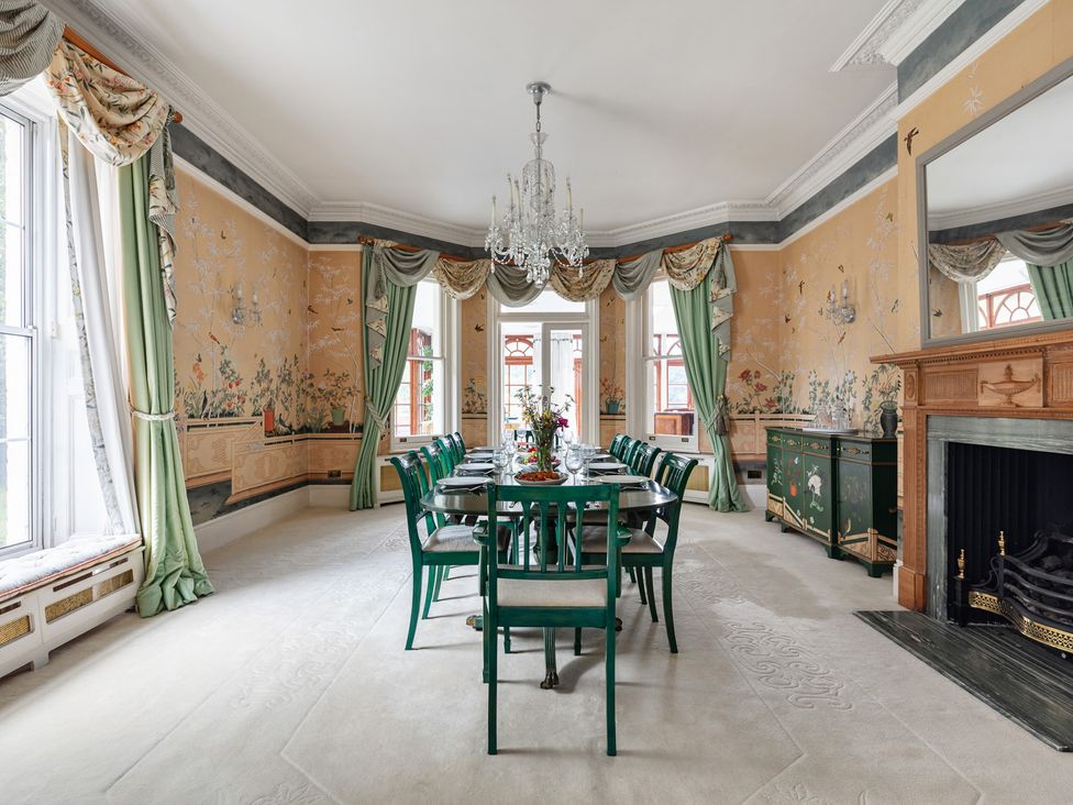 A dining room with a chandelier and a decorative table at Violet House in Iver