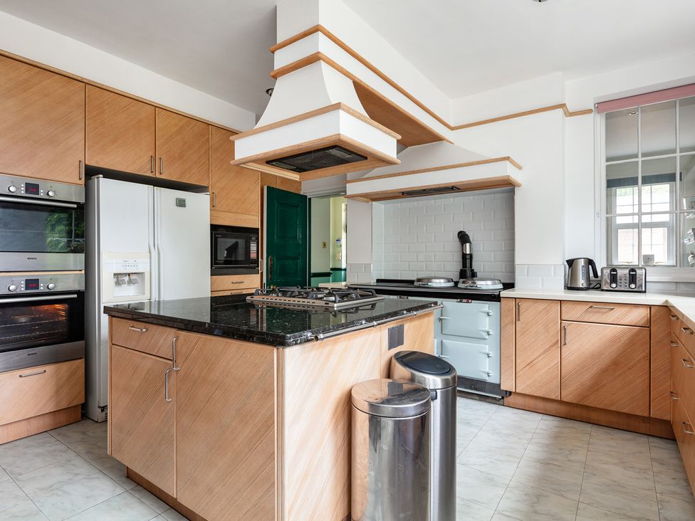 A kitchen with appliances and cabinets at Violet House in Iver