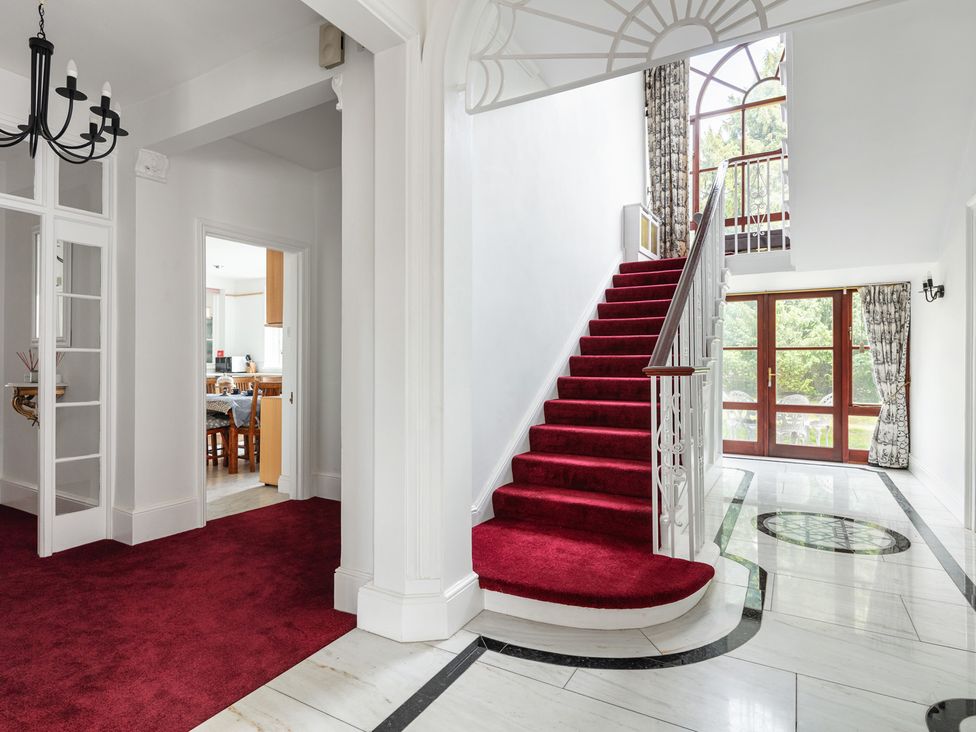 A hallway with a staircase and a doorway at Violet House in Iver