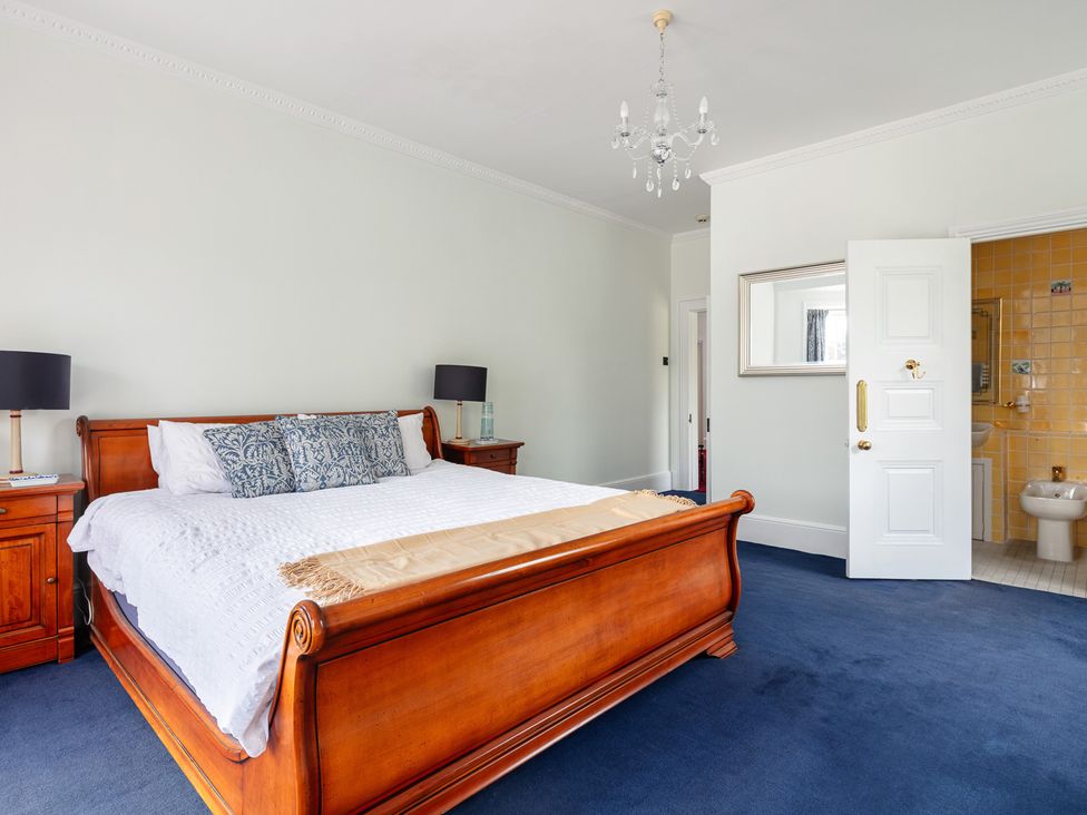 A bedroom with a bed and nightstands at Violet House in Iver