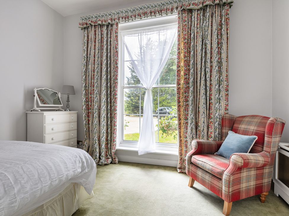A bedroom with a bed and chair at Violet House in Iver