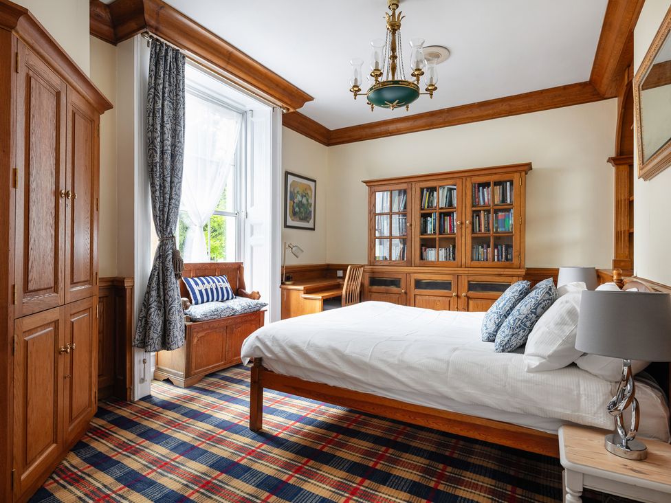 A bedroom with a bed and bookshelf at Violet House in Iver