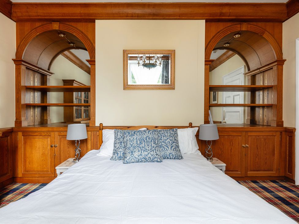 A bedroom featuring a bed and built-in shelves at Violet House in Iver