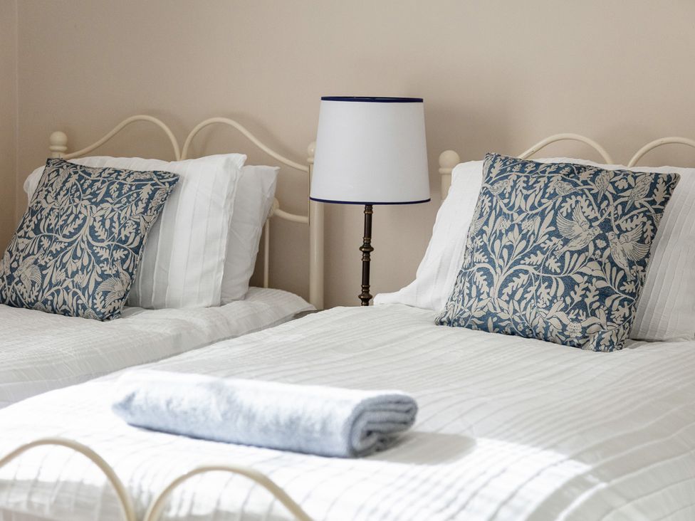 A bedroom with two beds and a lamp at Violet House in Iver