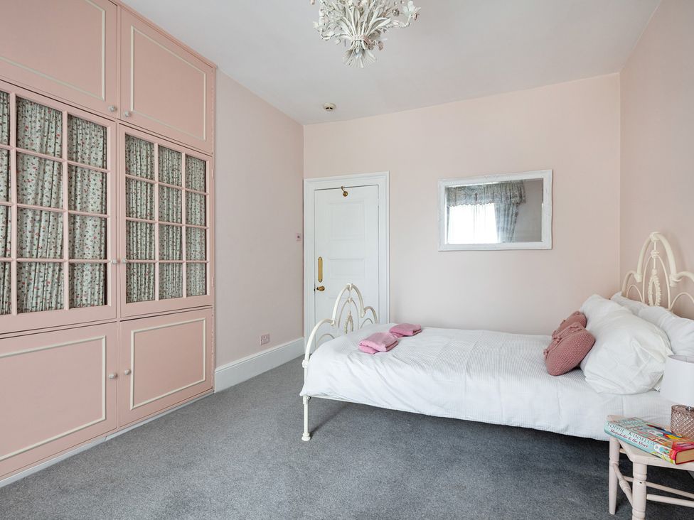 A bedroom with a bed and wardrobe at Violet House in Iver