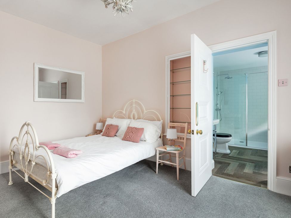 A bedroom with a bed and attached bathroom at Violet House in Iver