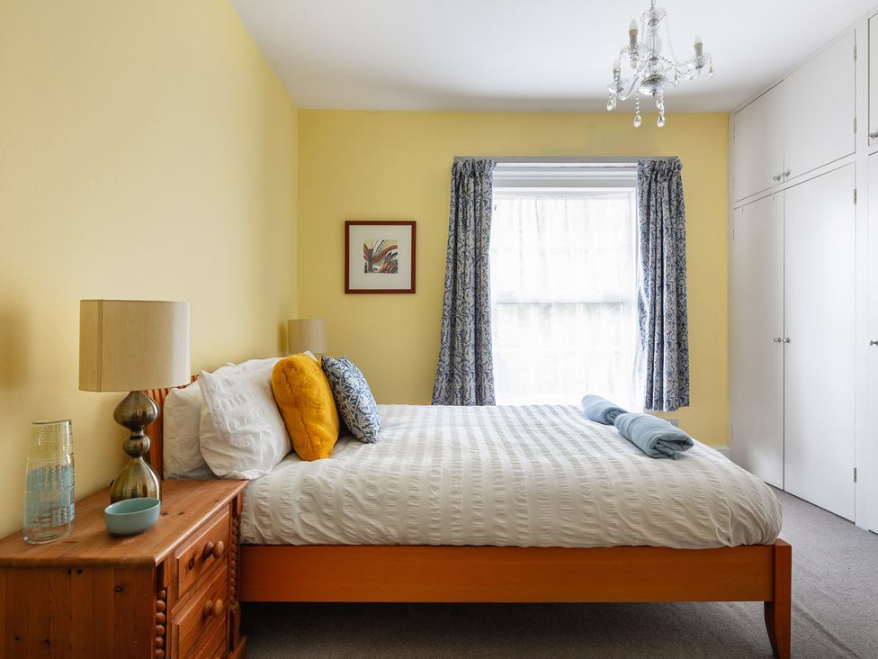 A bedroom with a double bed and a nightstand at Violet House Iver
