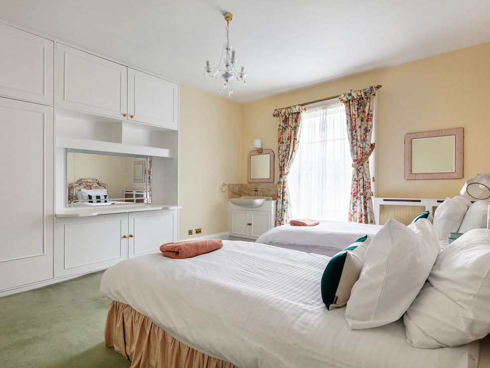 A bedroom with two beds and a mirror at Violet House in Iver