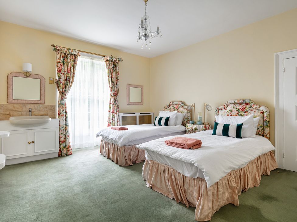 A bedroom with two beds and a sink area at Violet House in Iver