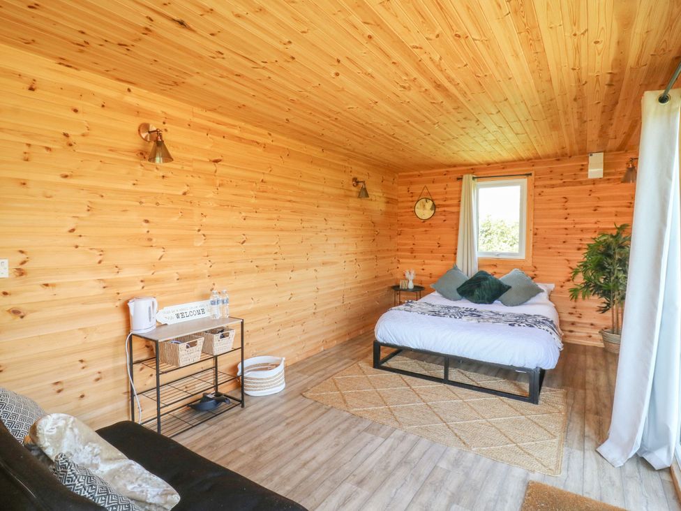 A bedroom with a bed and a sofa at Bluebell Lodge in Hastings