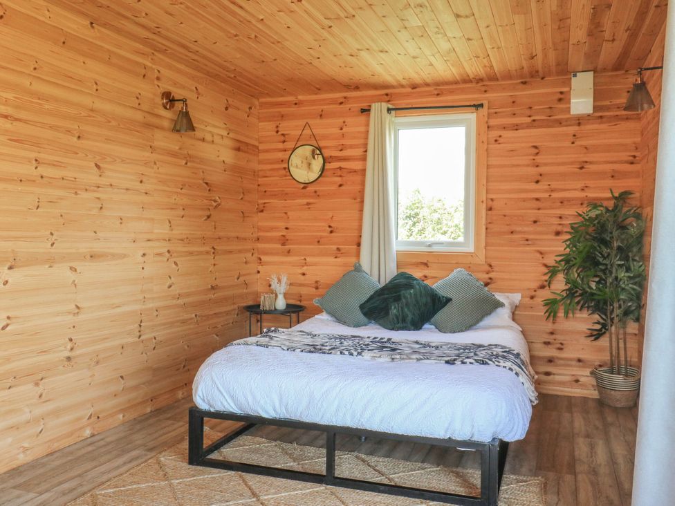 A bedroom with a bed and bedside table at Bluebell Lodge in Hastings
