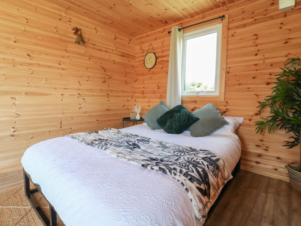 A bedroom with a bed and window at Bluebell Lodge in Hastings