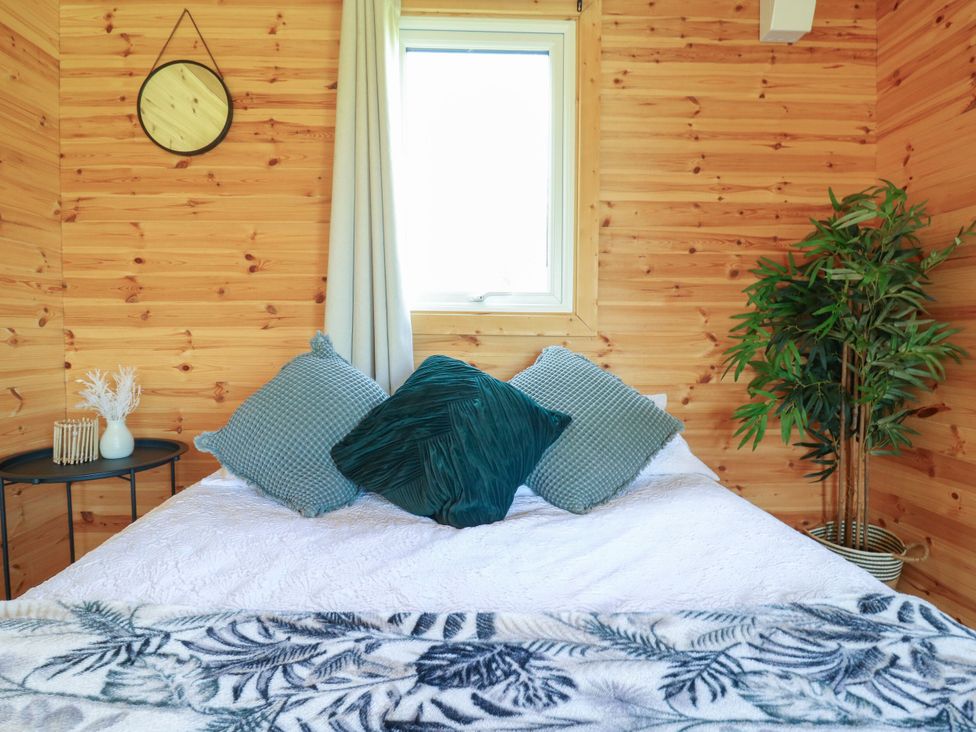 A bedroom with a bed and decorative pillows at Bluebell Lodge in Hastings