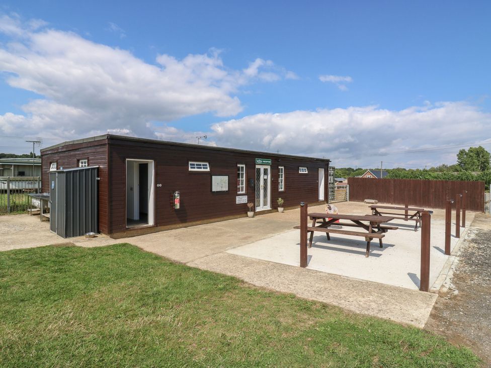 An outdoor area with a building and picnic table at Bluebell Lodge in Hastings