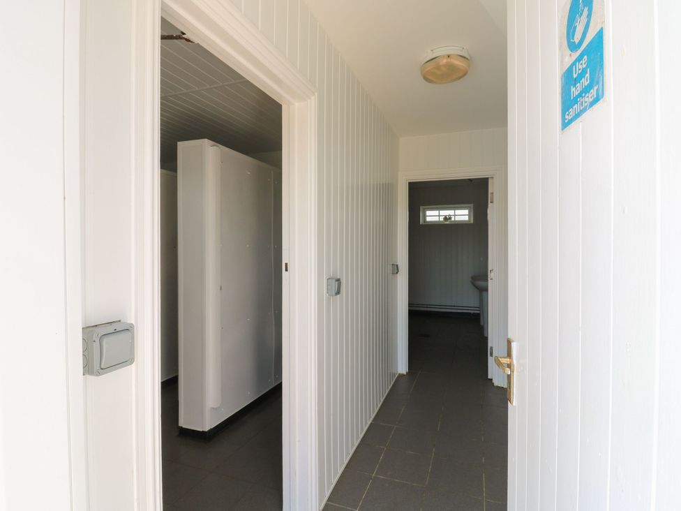 A hallway with doors leading to bathrooms at Bluebell Lodge in Hastings