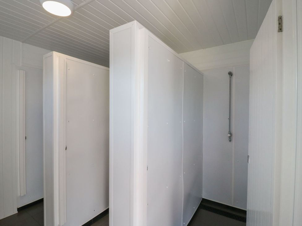A bathroom with multiple shower stalls at Bluebell Lodge Hastings