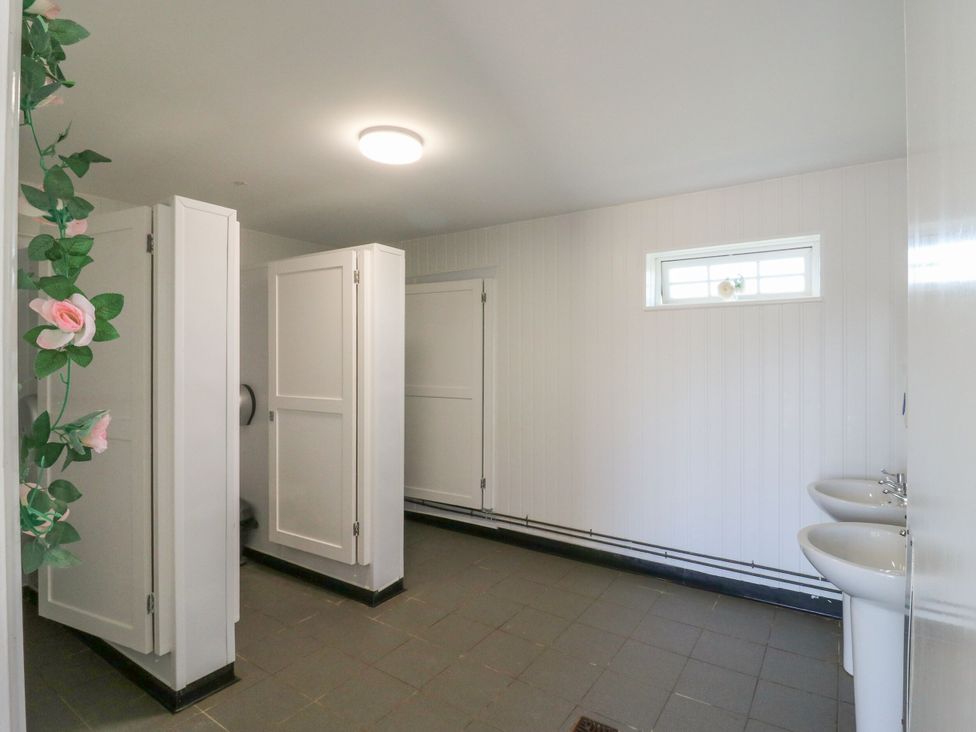 A bathroom with toilet stalls and sinks at Bluebell Lodge in Hastings