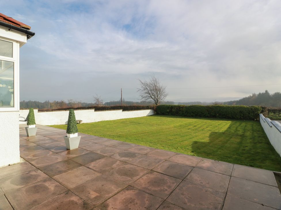A garden with a paved area and planters at Marchdyke Farm Cottage Dalton near Annan