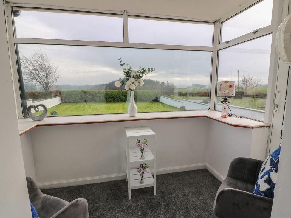 A conservatory with a table and vase at Marchdyke Farm Cottage Dalton near Annan
